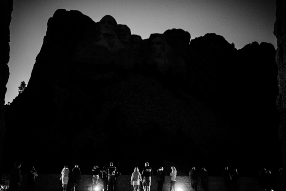 Crowds gather at dusk, awaiting the lighting of the four Presidents