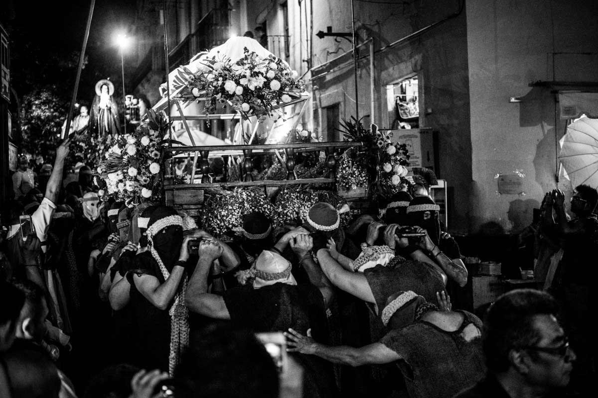 The brotherhood bearing the body of Christ are helped down the stairs from Plaza de San Fernando to the main street. Roman soldiers lift power lines with their spears above the floats to avoid any tangling.