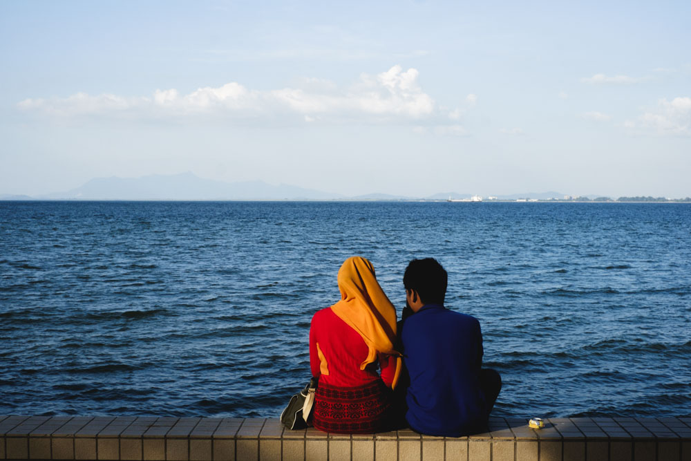 Locals enjoying each other's company by the Esplanade seaside. Georgetown, Penang.