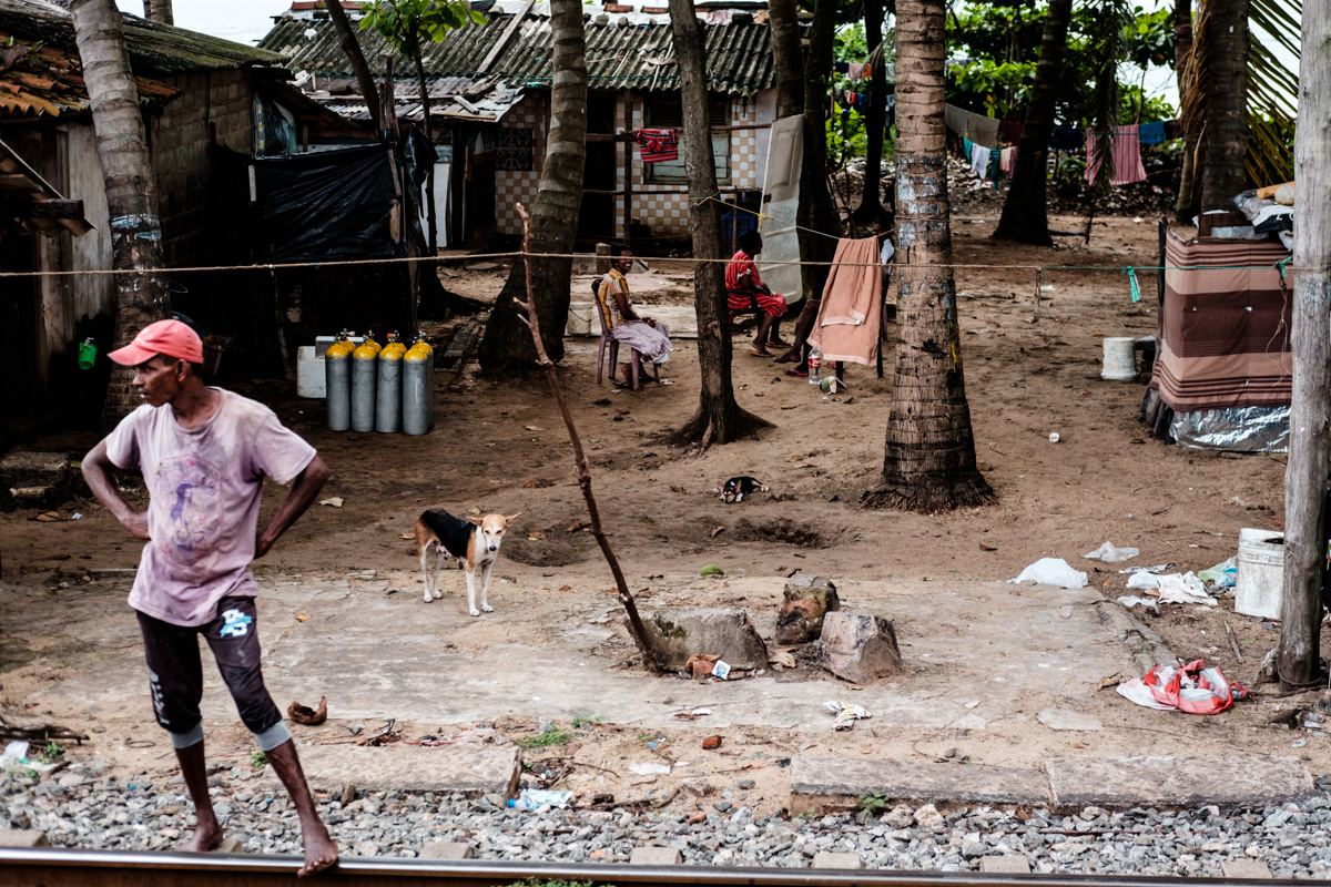Residents of the shanties on the beach side of Dehiwala station relax in the heat of the afternoon