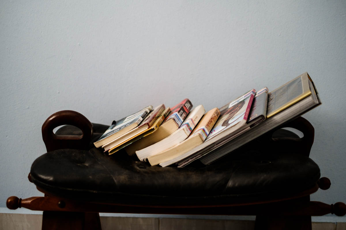 Library books rest on a foot stool in my room in Singapore