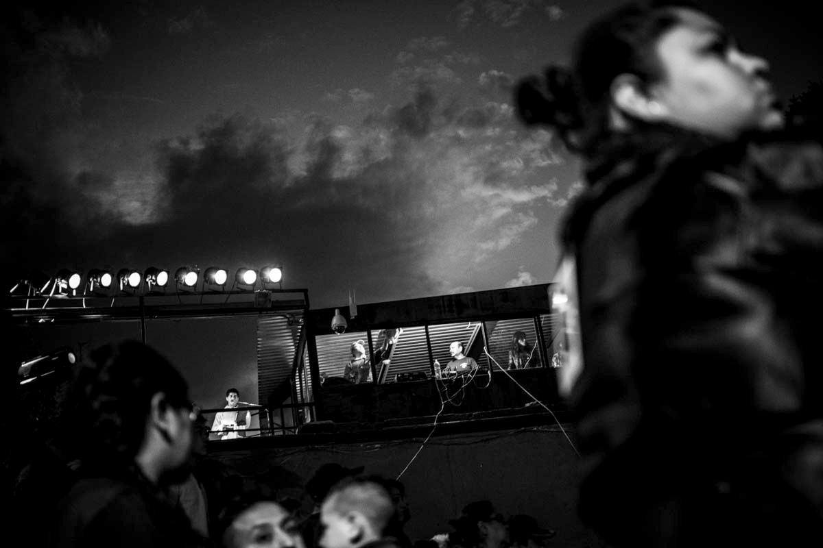 The priest leads the service from the roof of one of the buildings surrounding the plaza - which is outfitted with a full AV control room for performances.